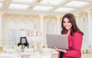 happy-event-manager-using-laptop-banquet-hall_23-2148085315